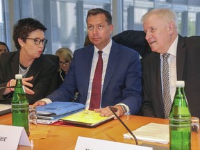 German Interior Minister Horst Seehofer, Stephan Mayer, state secretary in the Interior Ministry, and Jutta Cordt, president of the German federal office for migration and refugees, from right, attend a meeting of the interior committee of the German parliament in Berlin, Tuesday, May 29, 2018.