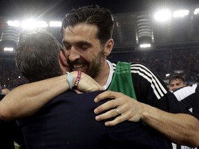 Juventus goalkeeper Gianluigi Buffon celebrates with a team staffer at the end of the Serie A soccer match between Roma and Juventus, at the Rome Olympic stadium, Sunday, May 13, 2018. The match ended in a scoreless draw and Juventus won record-extending seventh straight Serie A title.