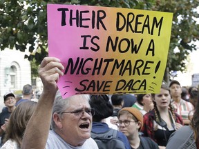 FILE - In this Sept. 15, 2017, file photo, Judy Weatherly, a supporter of the Deferred Action for Childhood Arrivals (DACA) holds up a sign during a protest outside of the Federal Building in San Francisco. The Trump administration will try to convince a U.S. appeals court that it was justified in ending an Obama-era immigration policy that shielded hundreds of thousands of young immigrants from deportation. The 9th U.S. Circuit Court of Appeals, based in San Francisco, on Tuesday, May 15, 2018, will be the first federal appeals court to hear arguments about President Donald Trump's decision to phase out the Deferred Action for Childhood Arrivals program.