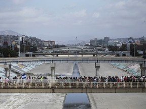 FILE - In this April 29, 2018 file photo, Central Americans who travel with a caravan of migrants they walk towards the border before crossing the border and request asylum in the United States, in Tijuana, Mexico. The group that led a monthlong caravan of Central Americans seeking asylum in the United States wanted to draw attention to the plight of people in the violent region.