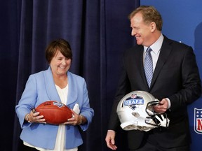 Tennessee Titans owner Amy Adams Strunk holds a football as she and NFL commissioner Roger Goodall prepare for a photo after it was announced that Nashville will host the 2019 NFL draft during the NFL owner's spring meeting Wednesday, May 23, 2018, in Atlanta.