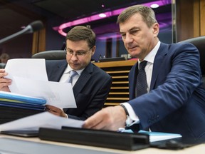 European Commissioner for Financial Stability, Financial Services and Capital Markets Union Valdis Dombrovskis, left, and European Commissioner for Digital Single Market Andrus Ansip read documents at the start of a meeting of the college of commissioners at EU headquarters in Brussels on Wednesday, May 23, 2018.