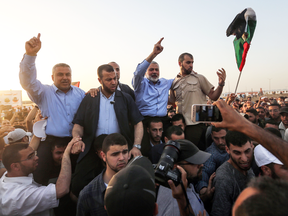 Hamas  leader Ismail Haniya, centre, gestures to demonstrators at a a protest camp during clashes with Israeli forces along the Gaza border, May 18, 2018.