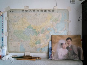A wedding photo of Han's younger son is displayed in Han's living room/bedroom. The son's family migrated to Canada in 2003.