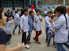 In this Tuesday, May 22, 2018 photo, Sarah, center left, a Palestinian refugee from Syria speaks with her colleagues during a break at the Jafna Elementary school, run by the U.N. Agency for Palestinian Refugees, UNRWA, in the eastern Bekaa Valley town of Taalabaya, Lebanon. Sarah has come a long way since she arrived in Lebanon after fleeing Syria's civil war five years ago, and is now a star student at an elementary school run by UNRWA, which also provides trauma counseling. But those services, and the thousands of children who rely on them, now face an uncertain future, as the U.S. threatens to cut funding.