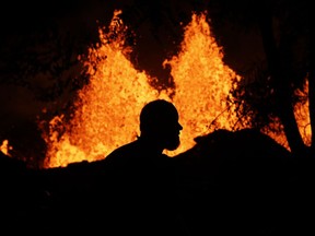 A photographer records lava erupting from a fissure in Kapoho, Hawaii Monday, May 21, 2018. The eruption of Kilauea volcano in Hawaii sparked new safety warnings about toxic gas on the Big Island's southern coastline after lava began flowing into the ocean and setting off a chemical reaction.