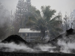 Toxic gases rise near an abandoned home in the Leilani Estates subdivision near Pahoa, Hawaii Friday, May 18, 2018. Hawaii residents covered their faces with masks after a volcano menacing the Big Island for weeks exploded, sending a mixture of pulverized rock, glass and crystal into the air in its strongest eruption of sandlike ash in days.