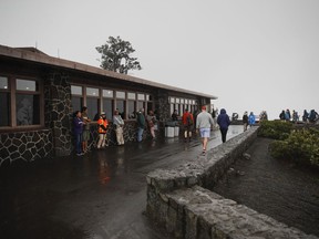 People stand outside the Jaggar Museum overlooking Kilauea's summit crater in Volcanoes National Park, Hawaii, Thursday, May 10, 2018. The park is closing Friday due to the threat of an explosive volcanic eruption.