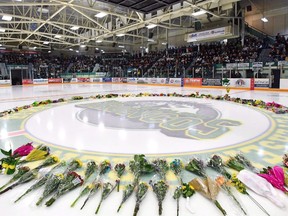 Flowers lie at centre ice as people gather for a vigil at the Elgar Petersen Arena, home of the Humboldt Broncos, to honour the victims of a fatal bus accident in Humboldt, Sask. on April 8.