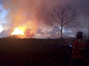 In this photo provided by the U.S. Geological Survey, crews make visual observations of lava activity at fissure 8, Thursday, May 31, 2018 near Pahoa, Hawaii. Fountain heights Thursday morning continued to reach 230 to 260 feet (70 to 80 meters) above ground level. The fountaining feeds a lava flow that is moving to the northeast along Highway 132 into the area of Noni Farms road.