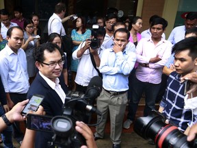 Kay Kimsong, left wearing glasses, editor-in-chief of the Phnom Penh Post, speaks to reporters after being fired by the newspaper's new owner for a report it published Monday about the publication's sale and its new owner, in Phnom Penh, Cambodia, Monday, May 7, 2018. The newspaper's sale was announced Sunday by its former publisher, Australian businessman Bill Clough, with the buyer being a little-known Malaysian public relations executive, Sivakumar Ganapathy who has links to the Cambodian government. (AP Photo)