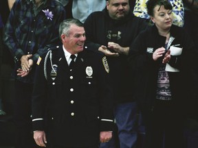 Mark Dallas, a school resource officer, reacts as he leads Dixon High School's Class of 2018 into their graduation ceremony in Lancaster Gymnasium at the school in Dixon, Ill., Sunday, May 20, 2018. Matthew A. Milby Jr., 19, is charged with firing shots inside of his northern Illinois high school Wednesday as seniors met for graduation rehearsal at the school before he was shot by Dallas. Milby was released from a hospital Thursday and transferred to the jail.