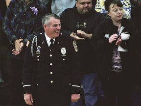 FILE - In this May 20, 2018 file photo, Mark Dallas, a school resource officer, leads Dixon High School's Class of 2018 into their graduation ceremony at the school in Dixon, Ill. Dallas told NBC's Today Show he was in his Dixon High School office May 16 when he heard gunfire in the hallway. Dallas says he recognized the gunman and knew he needed to stop him from entering the gym, where graduation rehearsal was begin held. Dallas says he yelled at Matthew Milby Jr. and the two exchanged shots. Dallas chased Milby outside, where he took Milby into custody after shooting him in the shoulder.