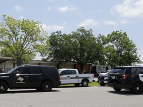 Law enforcement vehicles are parked outside the Alamo Gym where students and parents wait to reunite following a shooting at Santa Fe High School Friday, May 18, 2018, in Santa Fe, Texas.