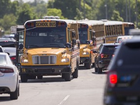 Empty school buses leave after a shooting at Noblesville West Middle School in Noblesville, Ind., on Friday, May 25, 2018. A male student opened fire at the suburban Indianapolis school wounding another student and a teacher before being taken into custody, authorities said.