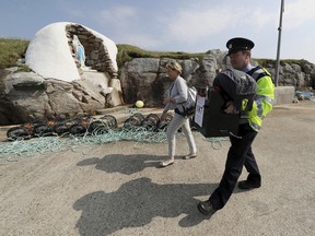 Garda police officer Pat McIlroy and Nancy Sharkey, Presiding Officer for Gola Island, arrive on the island off the coast of Donegal, Ireland, with a ballot box on Thursday May 24, 2018, as Islanders go to the polls a day ahead of the rest of the country to cast their vote in the referendum on the 8th Amendment of the Irish Constitution.