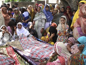 FILE - In this Friday May 18, 2018 file photo, People attend the funeral of Pakistani villagers allegedly killed by Indian shelling in Khanoor Mian, along the Line of Control in Pakistan. Pakistan and India have agreed to stop trading artillery fire in the disputed Himalayan region of Kashmir, and on Wednesday, May 30, 2018 the situation was calm after months of routine skirmishes that killed dozens of soldiers and civilians.