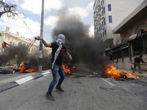 Palestinians sling stones during clashes with Israeli troops following a protest against the U.S. decision to relocate it's Israeli embassy to Jerusalem, in the West Bank city of Bethlehem, Monday, May 14, 2018.