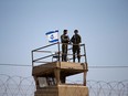 Israeli soldiers stand guard on a watch tower in a community along the Israel-Gaza Strip border on  May 15, 2018.