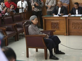 Radical Islamic cleric Aman Abdurrahman, center, sits on the defendant's chair during his trial at South Jakarta District Court in Jakarta, Indonesia, Friday, May 18, 2018. Abdurrahman is accused of being the key ideologue for IS militants in Indonesia and ordering attacks including a January 2016 suicide bombing and gun attack in the capital Jakarta that killed four civilians and four attackers.