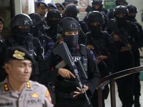 Members of Indonesian police counter terrorism unit Special Detachment 88 escort radical cleric Aman Abdurrahman upon arrival for his trial at a district court in Jakarta, Indonesia, Friday, May 25, 2018. Indonesia's parliament unanimously approved a stronger anti-terrorism law on Friday, lengthening detention periods and involving the military in counter-terrorism policing, spurred into action by recent bombings that involved children as perpetrators.