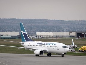 WestJet pilots voting overwhelmingly to give its union a strike mandate. WestJet planes are seen at the Calgary Airport in Calgary, Alta., Thursday, May 10, 2018.THE CANADIAN PRESS/Jeff McIntosh