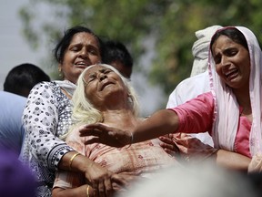 Indian women wail near the bodies of relatives, victims of cross-border firing, as they block a road during a protest against the state government in Ranbir Singh Pura, Jammu and Kashmir state, India, Friday, May 18, 2018. Eight civilians, including a husband and wife and four members of a family, were killed after Indian and Pakistani soldiers targeted border posts and villages along the highly militarized frontier in disputed Kashmir, officials said Friday. An Indian soldier was also killed in the fighting.