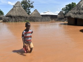 In this photo taken on Friday, April 27, 2018, a boy stands outside his family home, which has been submerged by floods following prolonged heavy rains in Tana Delta, Coastal Kenya.
