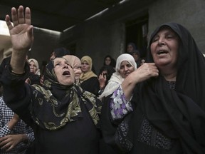 Relatives of 23 year-old Bahaa Qudeih mourn in the family house during his funeral in Khan Younis, southern Gaza Strip, Sunday, May 6, 2018. On Sunday Israeli troops shot and killed three Palestinians including Qudeih, who tried to breach the Gaza border fence, the military said, adding that an axe and a wire cutter were found in their possession.