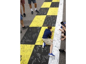 A young fan signs the finish line before the NASCAR Cup Series auto race at Kansas Speedway on Saturday, May 12, 2018, in Kansas City, Kan.