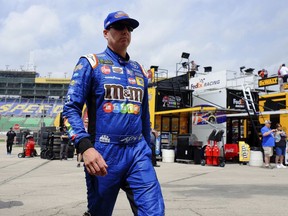 Driver Kyle Busch walks to his car prior for a practice round for this weekend's NASCAR Cup Series auto race at Kansas Speedway Friday, May 11, 2018, in Kansas City, Kan.