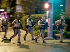 FILE - In this Oct. 1, 2017, file photo, police run toward the scene of a shooting near the Mandalay Bay resort and casino on the Las Vegas Strip in Las Vegas. Police in Las Vegas plan to release witness statements and officer reports of the Oct. 1 gunfire that killed 58 people and injured hundreds in the deadliest mass shooting in modern U.S. history. The scheduled release of documents on Wednesday, May 16, 2018, comes more than seven months after the shooting on the Las Vegas Strip.