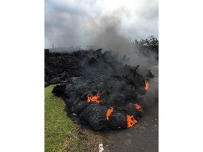 Lava burns across the road in the Leilani Estates in Pahoa, Hawaii, Saturday, May 5, 2018. Hundreds of anxious residents on the Big Island of Hawaii hunkered down Saturday for what could be weeks or months of upheaval as the dangers from an erupting Kilauea volcano continued to grow.