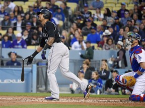 Colorado Rockies' Ian Desmond leaves the batter's box on a solo home run as Los Angeles Dodgers catcher Yasmani Grandal watches during the second inning of a baseball game Tuesday, May 22, 2018, in Los Angeles.