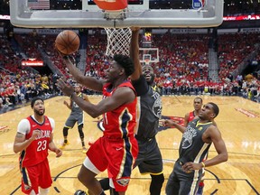 New Orleans Pelicans guard Jrue Holiday (11) goes to the basket against Golden State Warriors forward Draymond Green (23) in the first half of Game 4 of a second-round NBA basketball playoff series in New Orleans, Sunday, May 6, 2018.