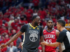 Golden State Warriors forward Draymond Green (23) challenges an official in front of New Orleans Pelicans forward E'Twaun Moore (55) in the first half of Game 4 of a second-round NBA basketball playoff series in New Orleans, Sunday, May 6, 2018.