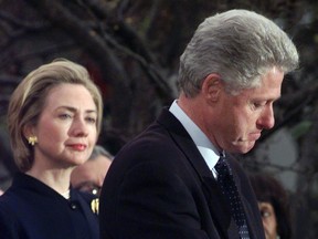 U.S. First lady Hillary Clinton watches U.S. President Clinton pause as he thanks those Democratic members of the House of Representatives who voted against impeachment in this Dec. 19, 1998 file photo.