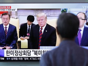 A man watches a TV screen showing footage of the summit meeting between U.S. President Donald Trump and South Korean President Moon Jae-in, left, during a news program at the Seoul Railway Station in Seoul, South Korea, Wednesday, May 23, 2018. North Korea on Wednesday allowed South Korean journalists to join the small group of foreign media in the country to witness the dismantling of its nuclear test site this week, Seoul officials said. The part of letters read "The summit meeting between U.S. President Donald Trump and South Korean President Moon Jae-in."