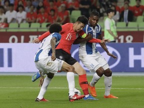South Korea's Son Heung-min, center, fights for the ball against Honduras Henry Figueroa, left, and Brayan Beckeles during their friendly soccer match in Daegu, South Korea, Monday, May 28, 2018.