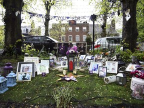 Tributes to George Michael  are seen outside his house in Highgate, north London, Wednesday, May 2, 2018. George's Michael's family is asking fans to remove flowers, photos and other tributes left outside the lake singer's two homes. A grassy square across from Michael's London house is bedecked in bouquets candles, flags and hand-written messages for the singer, who died in December 2016.
