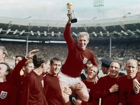FILE - In this July 30, 1966 file photo, England's soccer captain Bobby Moore, center, is carried by teammates Geoff Hurst, center left, and Ray Wilson as he holds FIFA World Cup after England defeated Germany 4-2 in the final at London's Wembley Stadium. Ray Wilson, the left back for all six of England's games in its World Cup-winning campaign in 1966, has died. He was 83. Former club Huddersfield announced Wilson's death on Wednesday, May 16, 2018. (AP Photo, file)