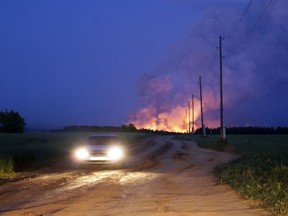 FILE - In this Friday, June 3, 2011 file photo, a fire engulfs an ammunition depot in Pugachyovo in the central Russian region of Udmurtia. Russia's emergency officials say they are evacuating residents from a village in central Russia after a nearby ammunition depot caught fire. The Emergency Situations Ministry said in a statement Wednesday, May 16, 2018 that they deployed a helicopter and a jet to put out a fire at the ammunition depot in the town of Pugachyovo. It was the second fire at the same depot in seven years. One person died and about 100 people sought medical help when a fire engulfed the depot in the summer of 2011.