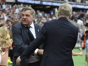 Everton manager Sam Allardyce, left, shakes hands with West Ham manager David Moyes, ahead of the English Premier League soccer match between West Ham United and Everton,  at the London Stadium, in London, Sunday May 13, 2018.