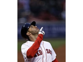 Boston Red Sox's J.D. Martinez points upward as he crosses home plate on his three-run home run off Oakland Athletics starting pitcher Trevor Cahill during the first inning of a baseball game at Fenway Park in Boston, Wednesday, May 16, 2018.
