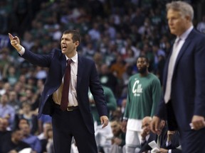 Boston Celtics coach Brad Stevens yells to his team as Philadelphia 76ers coach Brett Brown watches at right during the second half of Game 2 of an NBA basketball second-round playoff series, Thursday, May 3, 2018, in Boston. The Celtics won 108-103.