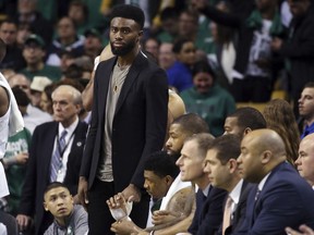 Injured Boston Celtics guard Jaylen Brown stands at the bench in street clothes as he watches the second half against the Philadelphia 76ers in Game 1 of an NBA basketball second-round playoff series, Monday, April 30, 2018, in Boston. The Celtics won 117-101.
