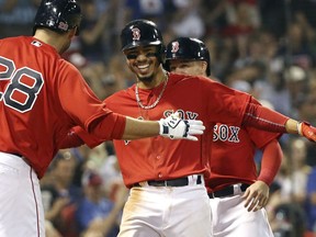 Boston Red Sox's Mookie Betts celebrates with J.D. Martinez (28) after hitting a two-run home run in the seventh inning of an inter-league baseball game against the Atlanta Braves at Fenway Park, Friday, May 25, 2018, in Boston.