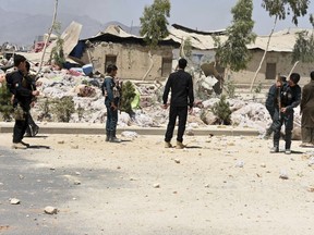 Security personnel inspect at the site of a deadly explosion in Kandahar, Afghanistan, Tuesday, May 22, 2018. An Afghan official says that at least 16 people, including four members of the security forces, died when a container full of explosives went off as they tried to defuse it. Spokesman Daud Ahmadi said dozens of people, including six members of the security forces and at least five small children, were wounded in the explosion.
