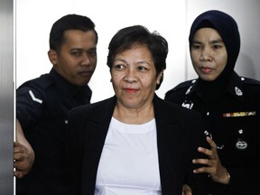 Australian Maria Elvira Pinto Exposto is escorted by police during a court hearing at Shah Alam High Court in Shah Alam, Malaysia. Exposto's lawyer, Thursday, May 24, 2018, says her client has been sentenced to death after an appeals court overturned a lower court's acquittal.