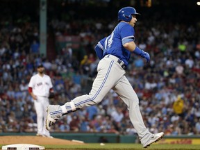 Toronto Blue Jays' Justin Smoak rounds first base on his solo home run off Boston Red Sox's Rick Porcello, left, during the fourth inning of a baseball game Tuesday, May 29, 2018, in Boston.